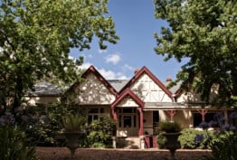 Colour photo of Dromkeen homestead, a federation-era timber home with stone steps and verandah