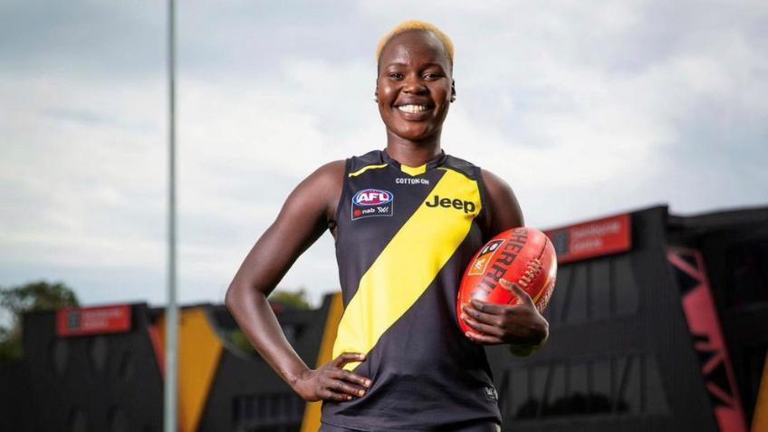 Woman in football jersey holding a football