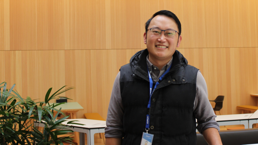 A smiling man wearing glasses indoors