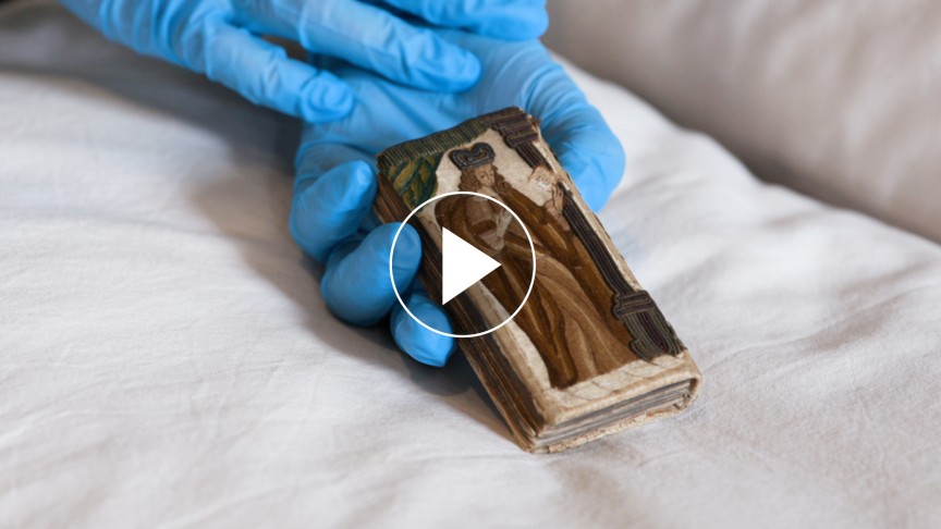Hands with blue gloves on holding a small book