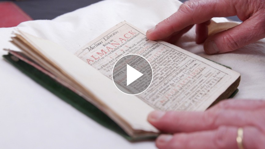 Two hands holding open a small book