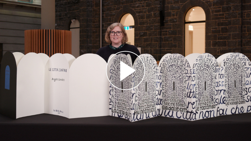 Anna Welch standing next to a concertina book from Melbourne artist and former fellow, Angela Cavalieri