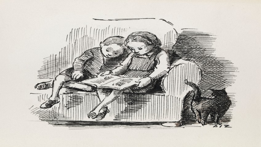 A boy and a girl read a book together on the couch